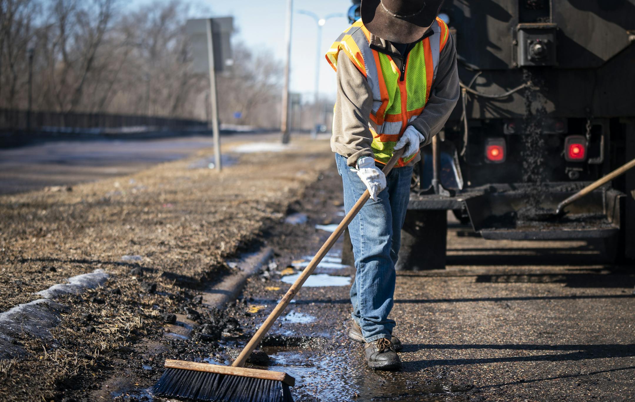 Street service worker Bradley Therres smooths asphalt over a pothole on Shepard Road. ] LEILA NAVIDI ¥ leila.navidi@startribune.com BACKGROUND INFORMATION: St. Paul Public Works street service workers patch potholes with asphalt on Shepard Road near Homer Street in St. Paul on Friday, March 15, 2019.