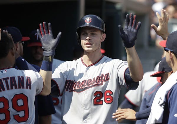 Minnesota Twins' Max Kepler is congratulated in the dugout after his solo home run during the ninth inning of a baseball game against the Detroit Tige