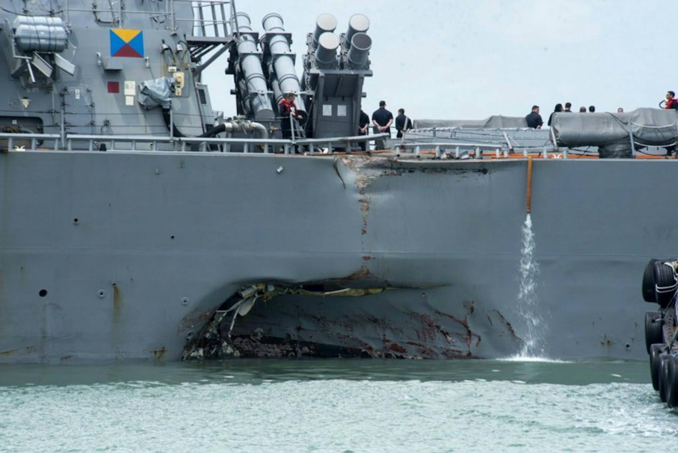 Damage to the portside is visible as the Guided-missile destroyer USS John S. McCain (DDG 56) steers towards Changi naval base in Singapore following a collision with the merchant vessel Alnic MC Monday, Aug. 21, 2017. The USS John S. McCain was docked at Singapore's naval base with "significant damage" to its hull after an early morning collision with the Alnic MC as vessels from several nations searched Monday for missing U.S. sailors.