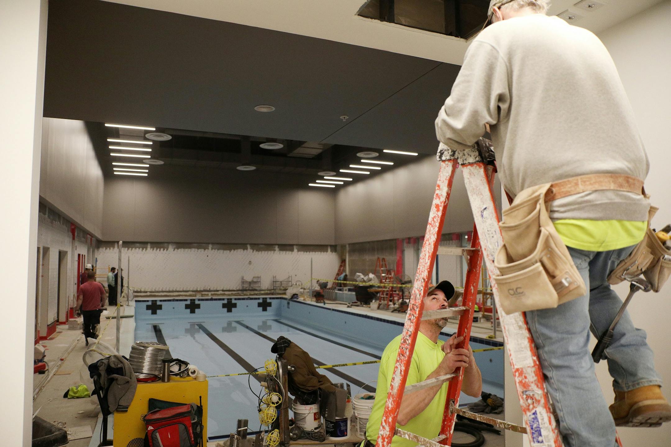Construction workers installed lights and vents in the pool and spa area.
