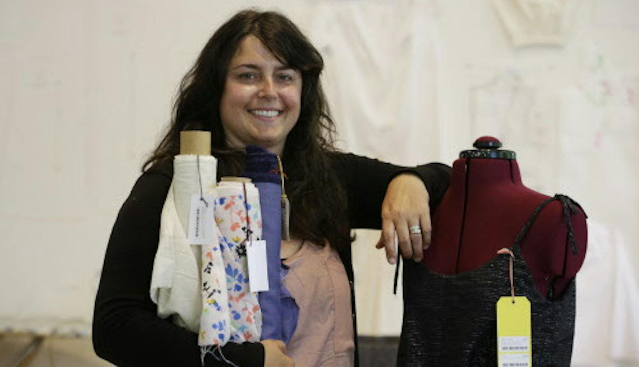 In this photo taken, Wednesday, July 1, 2015, Keli Faw poses for a photo in her shop, Drygoods Design, which she moved from the Ballard section of Seattle, to the Pioneer Square neighborhood. Rent hikes are forcing small businesses to move and revamp. (AP Photo/Elaine Thompson)