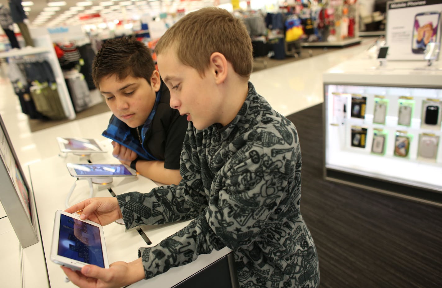 Kevin Gonzalez, 11, left, and, John Sederberg, 11, both from Minneapolis, watched "The Laser Collective" on one of the Samsung tablets on display in the newly renovated electronics department at Target in Minneapolis, Min., Wednesday, October 16, 2013 ] (KYNDELL HARKNESS/STAR TRIBUNE) kyndell.harkness@startribune.com