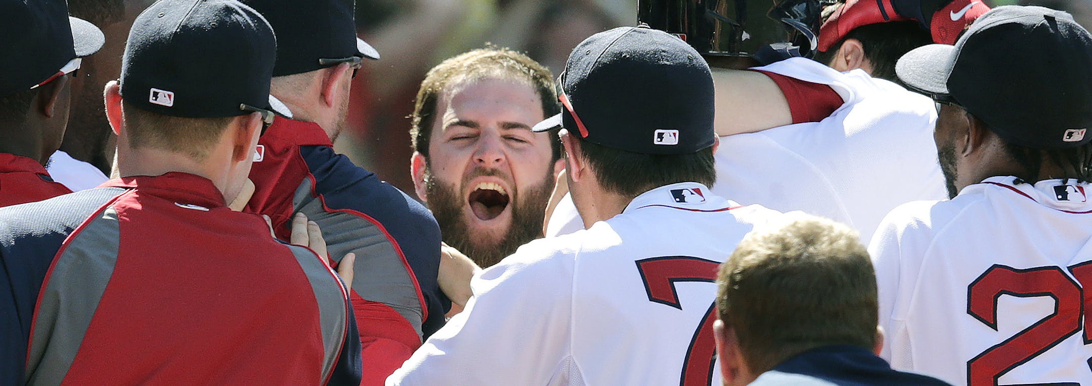 Boston Red Sox's Mike Napoli, center, smiles as he is congratulated by teammates after hitting the game-winning, walk-off home run against the Minnesota Twins in the 10th inning of a baseball game at Fenway Park in Boston, Wednesday, June 18, 2014. The Red Sox won 2-1 in 10 innings. (AP Photo/Charles Krupa)