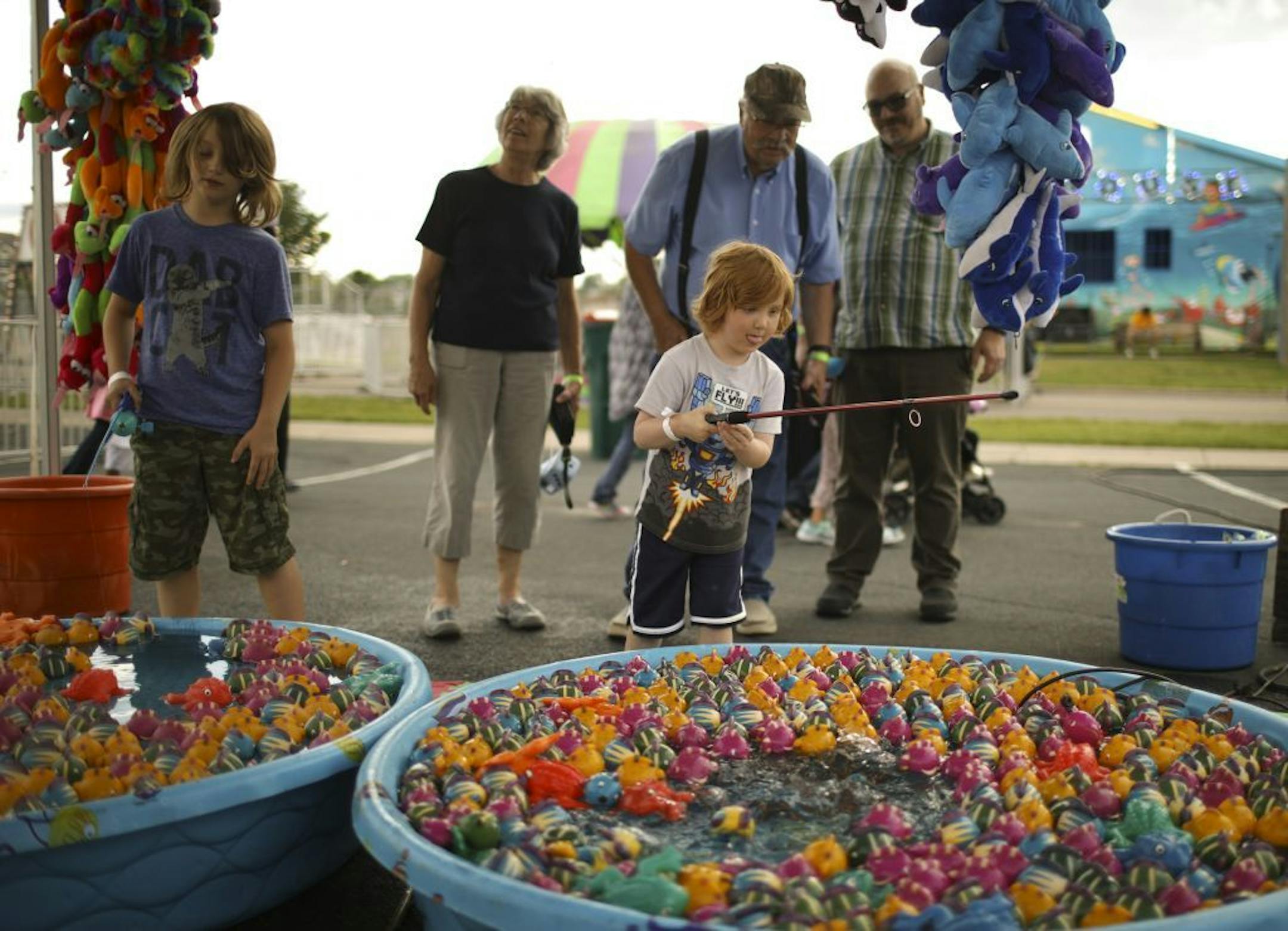 Silas, left, and Sam Wahl tried their luck fishing for prizes while attending the Heights Jamboree & Carnival Thursday evening with their grandparents, Shirley and Allen Wahl, and their dad, Jason, at rear, from left.