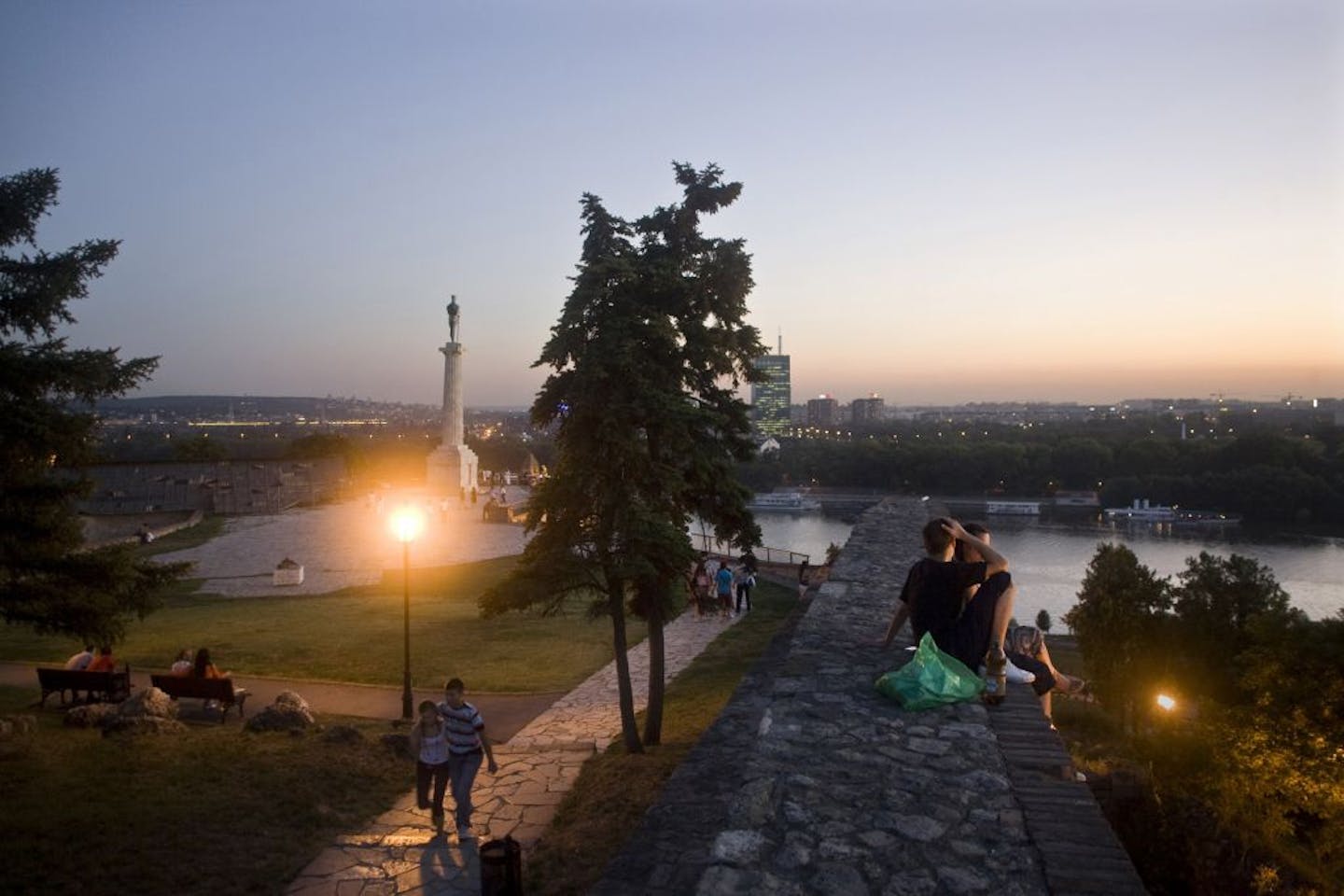 BELGRADE, SERBIA - AUGUST 8: people take in the view at Kalemegdan Fort during sunset August 8, 2008 in Belgrade, Serbia. "The Victor" Monument - the protector of Belgrade - stands on the left. Kalemegdan is the oldest section of the urban area of Belgrade and for centuries the city population was concentrated only within the walls of the fortress, thus the history of the fortress, until most recent history, equals the history of Belgrade itself. Kalemegdan is a popular spot for locals to enjoy