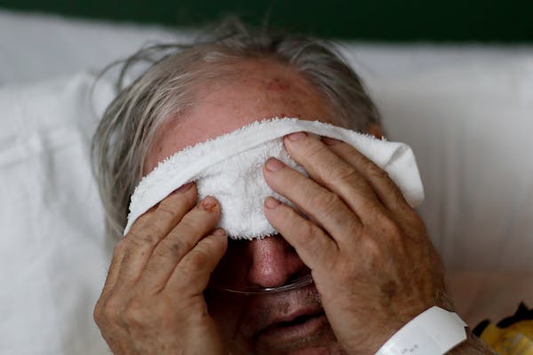 A man places a cold compress on his forehead while battling the flu at a hospital in Georgia. 