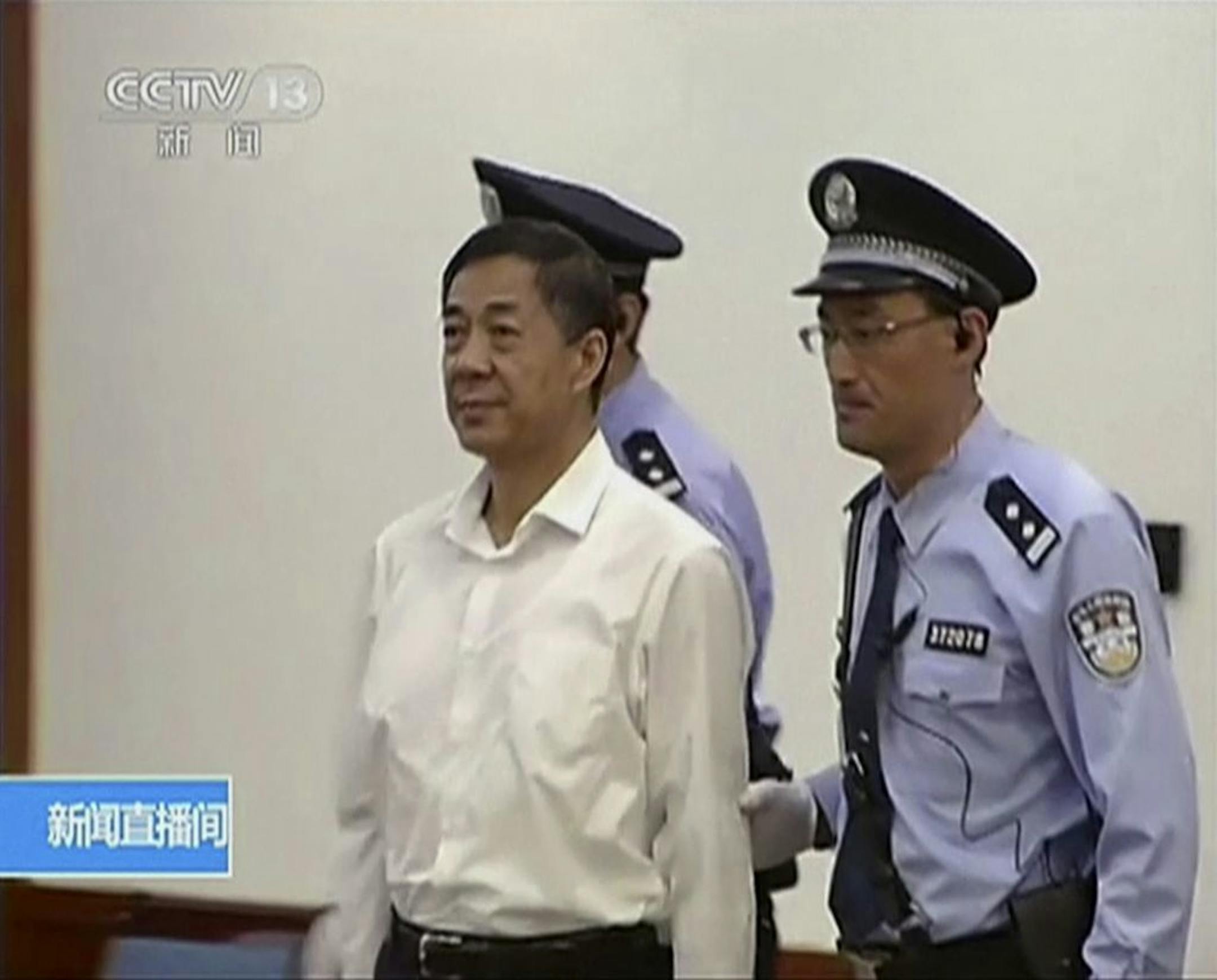 In this image taken from video, disgraced politician Bo Xilai, center, enters the courtroom, flanked by police guards at Jinan Intermediate People's Court in eastern China's Shandong province on Thursday Aug. 22, 2013.