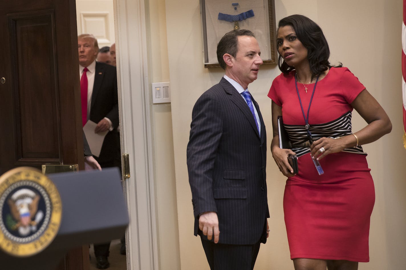 FILE -- Omarosa Manigault Newman and Reince Priebus, then the White House Chief of Staff, confer as President Donald Trump arrives in the Roosevelt Room at the White House, in Washington, Feb. 16, 2017.