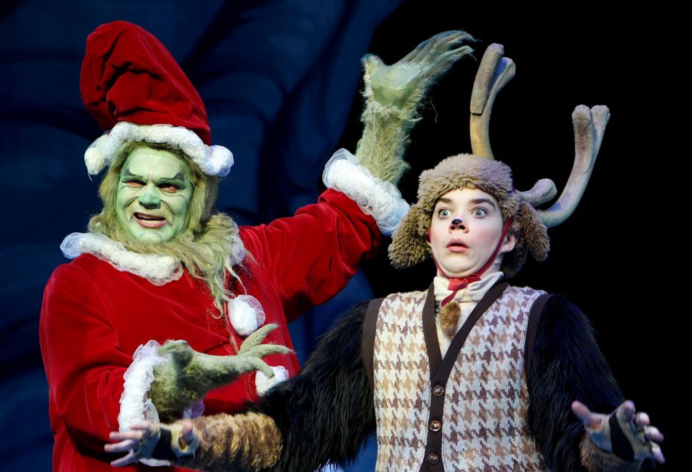 Reed Sigmund, left, plays The Grinch and Brandon Brooks plays his dog, Young Max, in "Dr. Seuss' How The Grinch Stole Christmas" at The Children's Theatre Company in Minneapolis November 4, 2012.