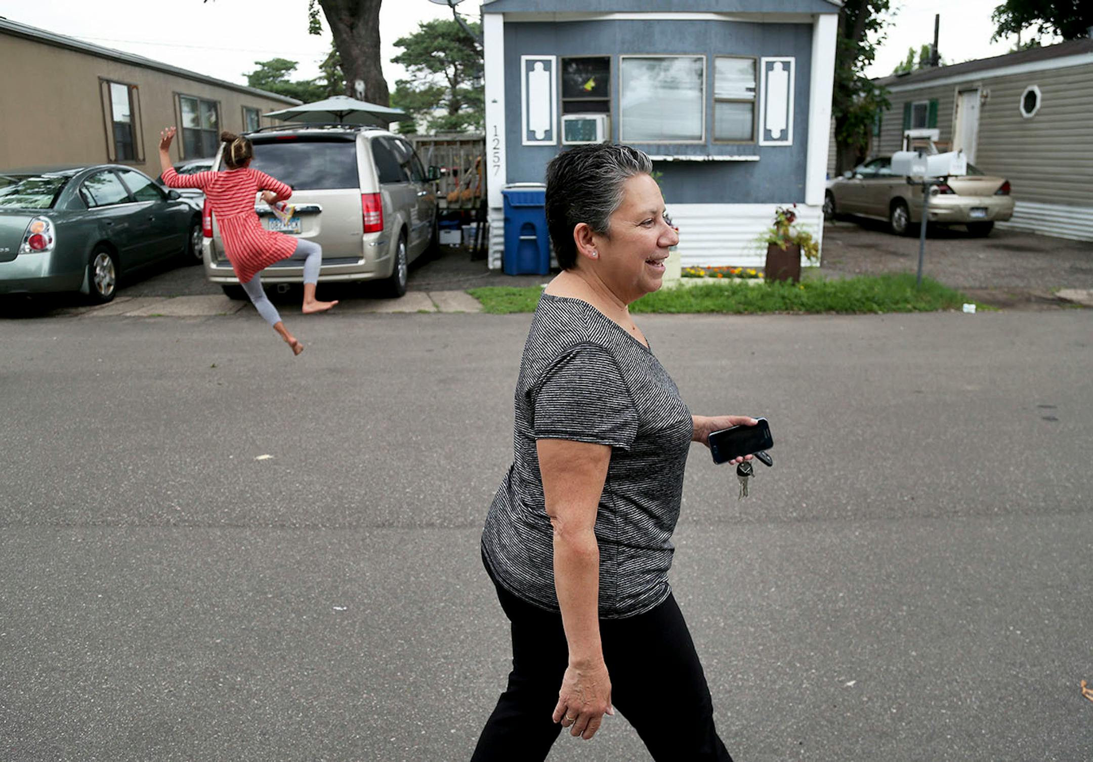 Natividad Seefeld, Park Plaza community board chair and resident walked through the Natividad Seefeld, Park Plaza community board chair and resident, walks through the mobile home park as resident Meadow Loch, 11, clicked her heals Wednesday, June 28, 2017, in Fridley, MN. Park Plaza has become a thriving cooperative community, owned by its residents and with no threat of closure.