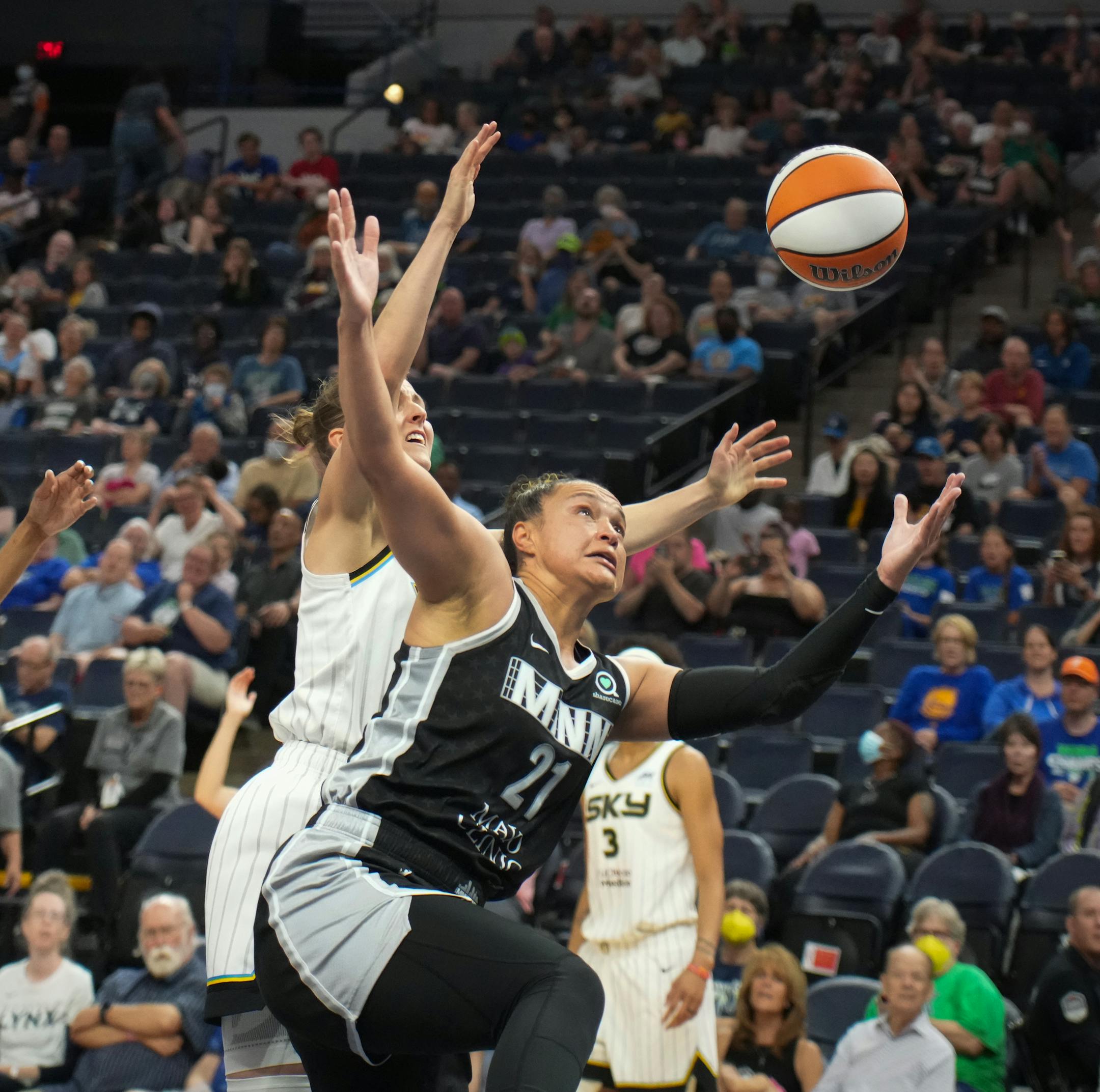 Minnesota Lynx guard Kayla McBride (21) and Chicago Sky guard Allie Quigley (14) battle for a rebound in the first half.