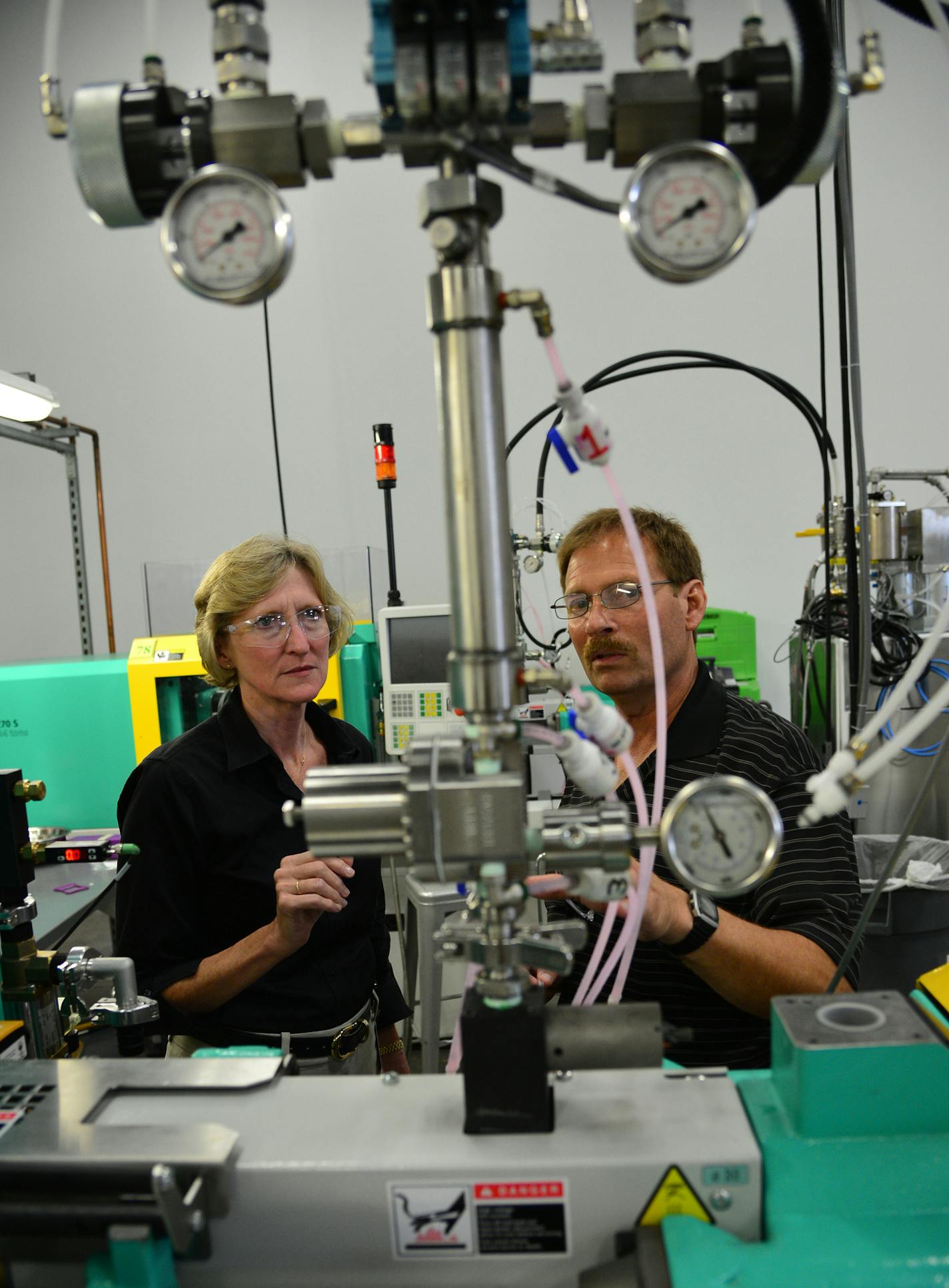 ProtoLabs's new CEO Vicki Holt has been on the job for 16 weeks and in that time negotiated and closed an acquisition, opened up a new $19 million factory and relocated to a new state. She looked over equipment in the injection molding area with Proto Labs silicon rubber injection specialist Rick Bigaouette]Richard.Sennott@startribune.com Richard Sennott/Star Tribune Maple Plain Minn.Thursday 6/26/2014) ** (cq)