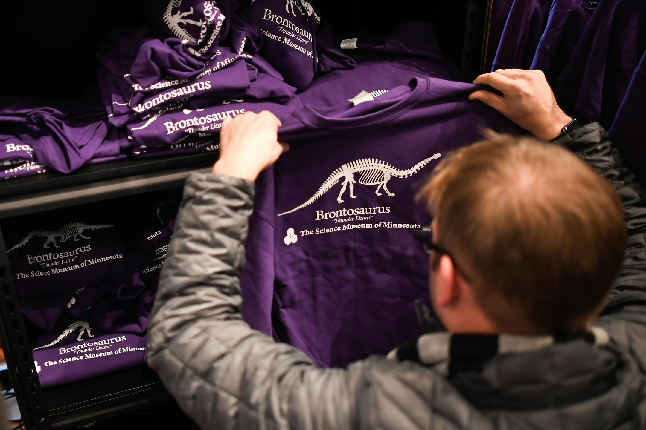 A customer at the Science Museum of Minnesota's gift shop perused through the selection of Brontosaurus shirts and sweatshirts made available to the public Tuesday morning.