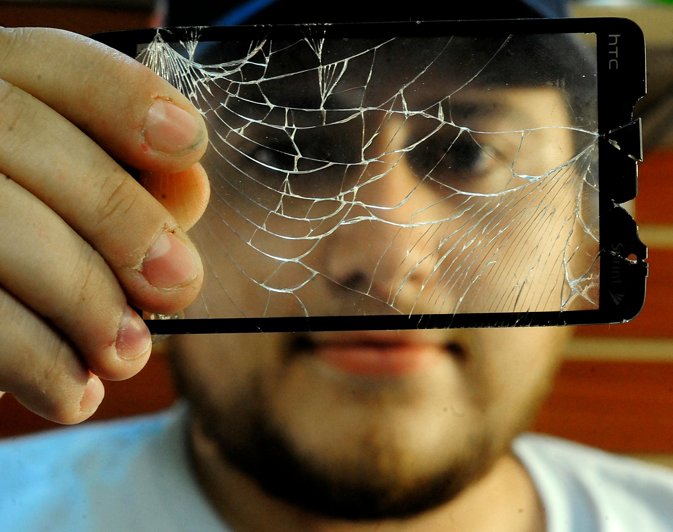 Miguel Jarquin shows the broken screen from a smartphone being repaired at his Cell Phone Tech repair shop in Davie, Florida, on August 11, 2011. Broken screens are the most common fixes he performs. (Joe Cavaretta/Sun Sentinel/MCT)