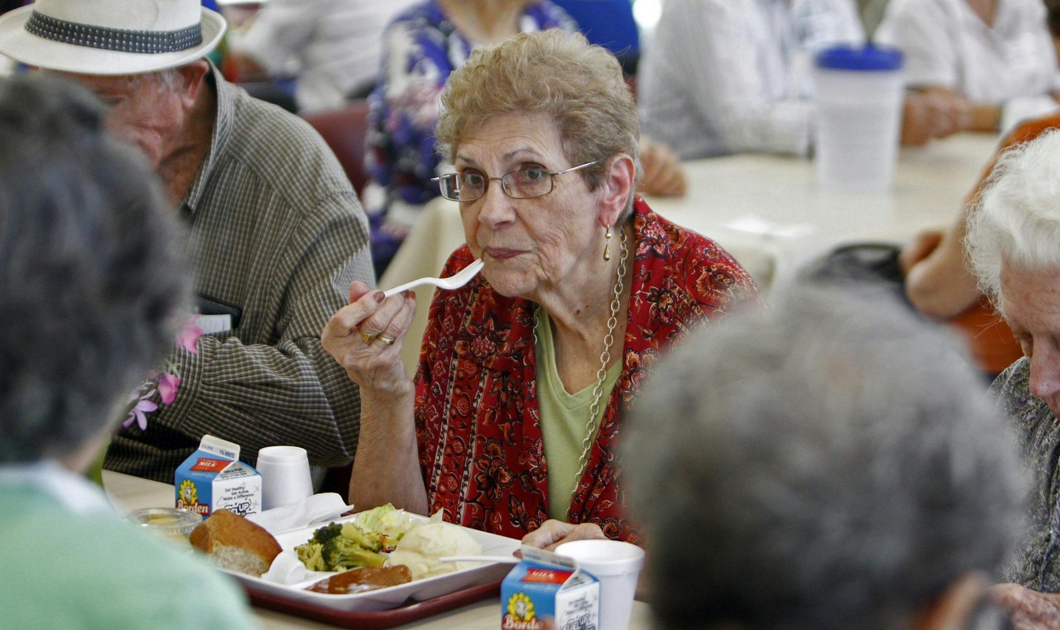 Migdalia Blanco, 84, center, enjoys her hot lunch at the Dr.Olga Martinez Center, August 16, 2013, in West Kendall County in Miami. The center feeds area senior citizens lunch Monday through Friday. The center has taken a hit to its programs due to the sequester budget cuts. (Emily Michot/Miami Herald/MCT)