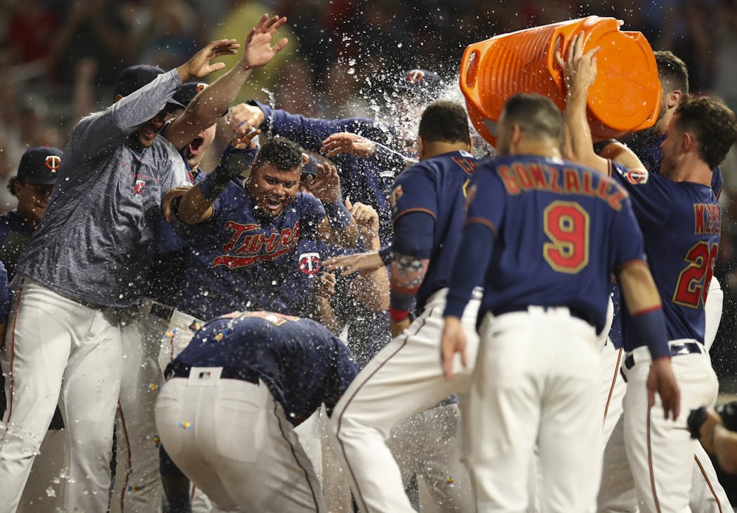 Teammates welcomed Minnesota Twins third baseman Miguel Sano (22) home after his game-winning homer.