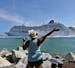 A woman from Cuba waves Adonia leaves port in Miami, Sunday, May 1, 2016, en route to Cuba. After a half-century of waiting, passengers finally set sa