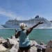 A woman from Cuba waves Adonia leaves port in Miami, Sunday, May 1, 2016, en route to Cuba. After a half-century of waiting, passengers finally set sa