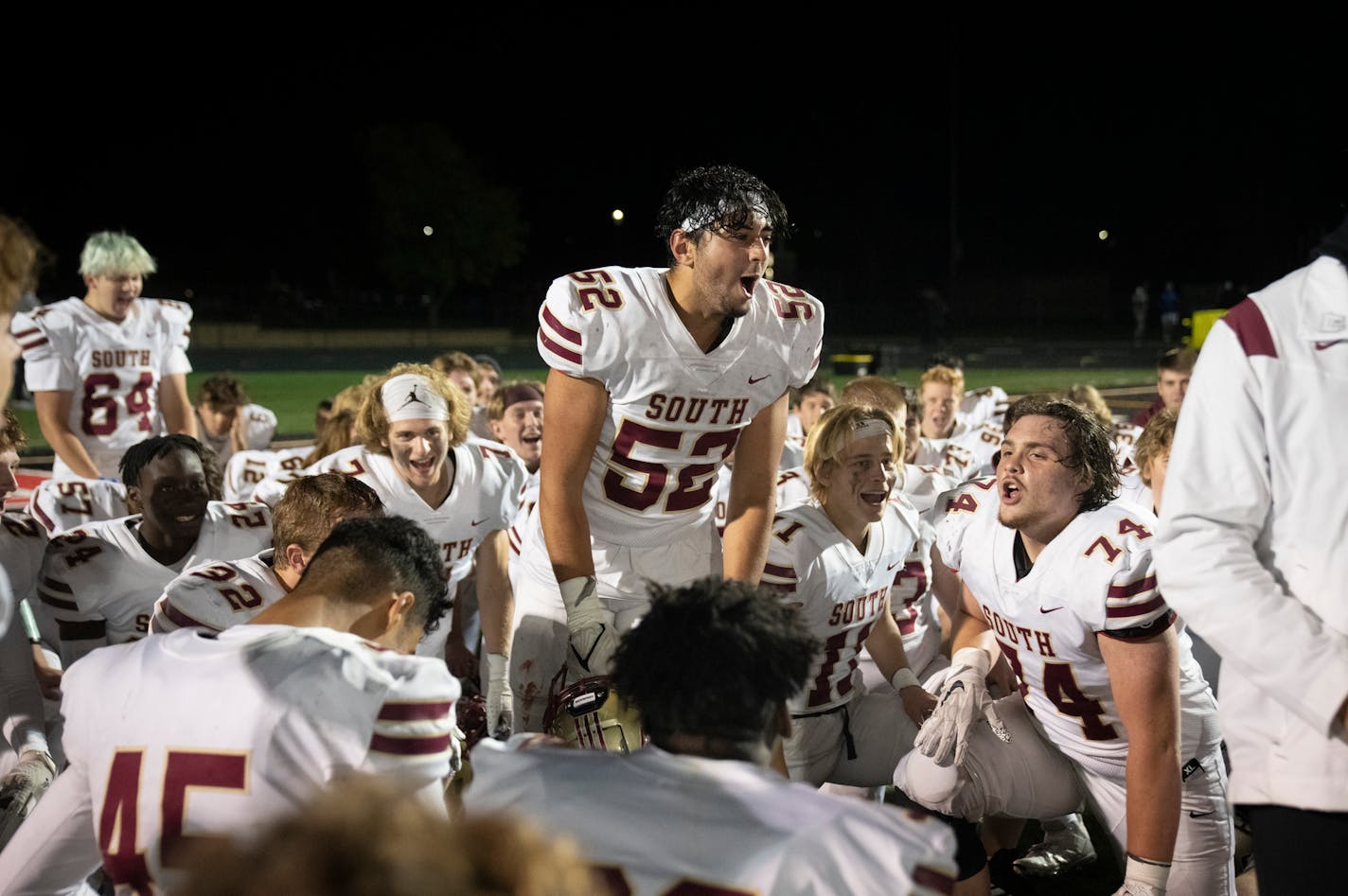 Lakeville South's Luke Steinhoff (52) stood up leading a celebration with teammates after they debriefed their 30-22 win over Shakopee.