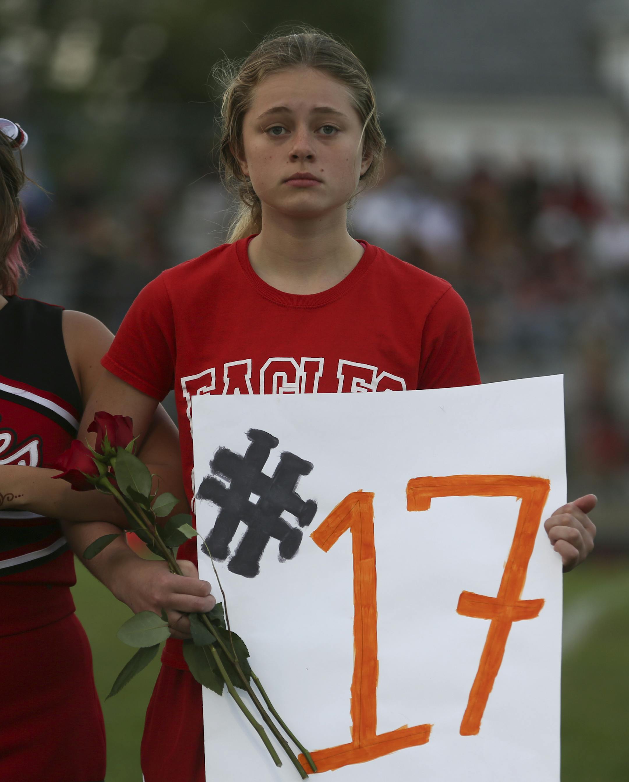 An eden prairie cheerleader held a sign that had Sha-Kym Adam's football number on it during a memorial service for the football player, who died in a drowning accident earlier this month, at the first football game of the season at South High School in Minneapolis, Minn. August 27, 2014. ] RENEE JONES SCHNEIDER • reneejones@startribune.com