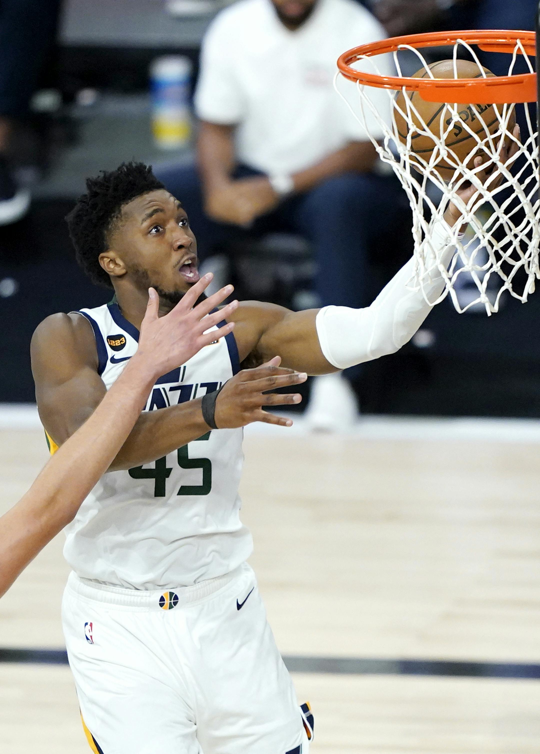 Utah Jazz's Donovan Mitchell, right, goes up for a shot against Denver Nuggets' Nikola Jokic during the second half of an NBA basketball first round playoff game, Monday, Aug. 17, 2020, in Lake Buena Vista, Fla. (AP Photo/Ashley Landis, Pool)