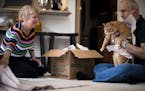 Larry Gomberg (right) pretends to pack their cat into a moving box as he and Martha Powers box up some of their last kitchen items at their Fairfax, V