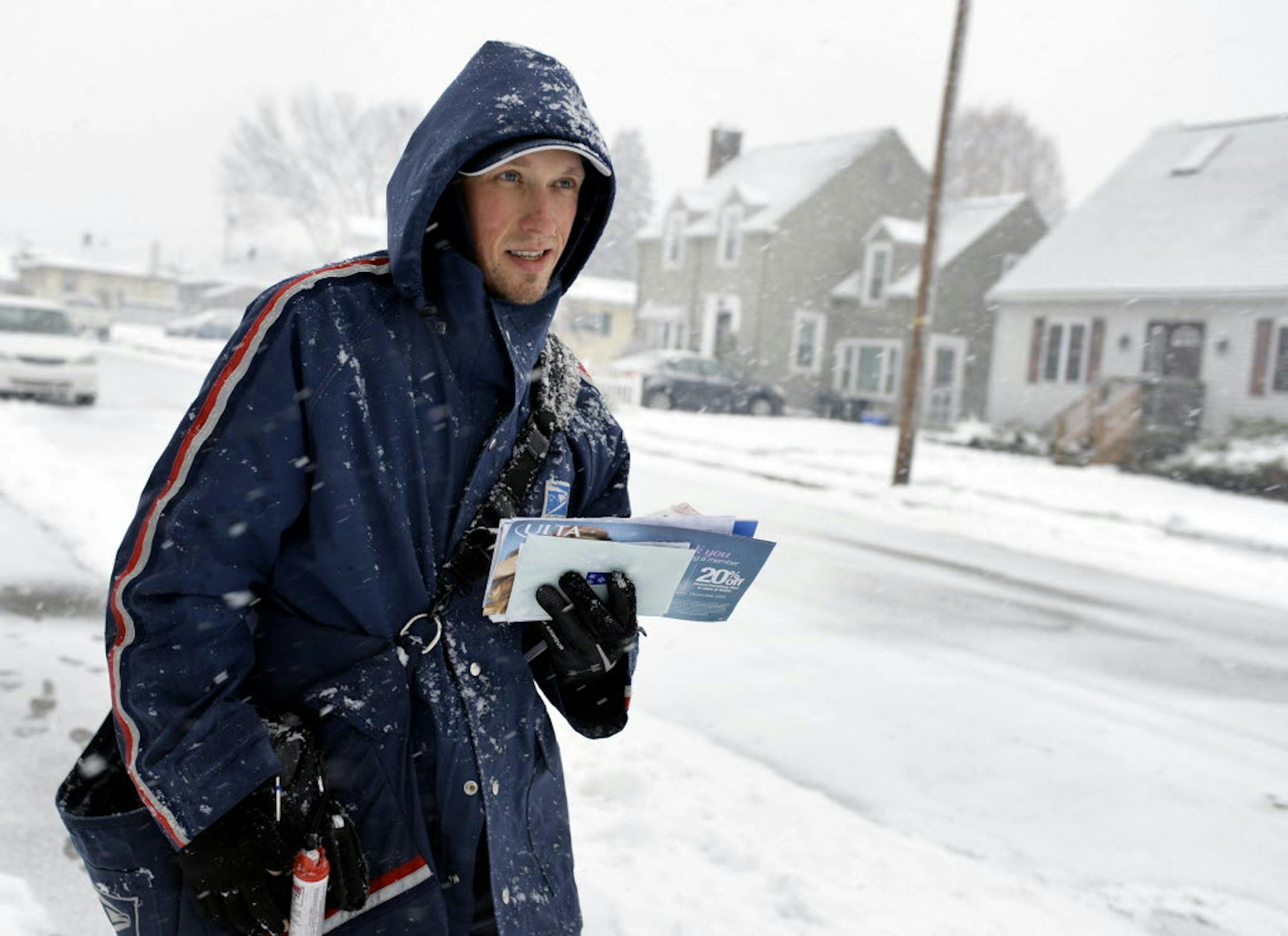 Mail carrier Greg Holler walks his route in West York as snow begins to fall on Saturday, Dec. 14, 2013.