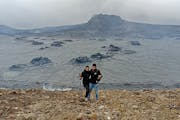 Mike Day and his wife, Laura, hiking the lava field of the Fagradalsfjall volcano in Iceland, which erupted in 2021, one of the adventures recounted i