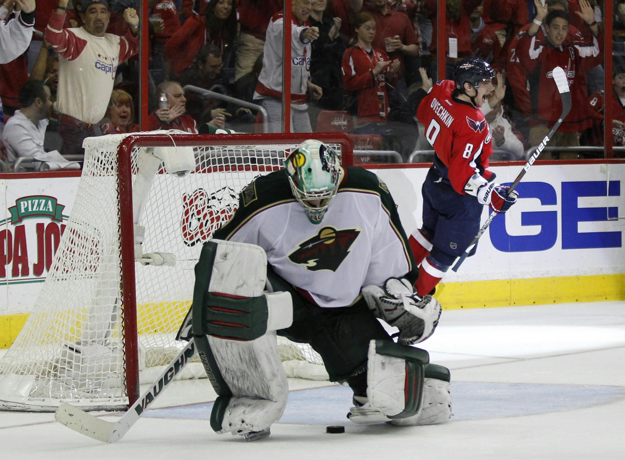 Washington Capitals goalie Braden Holtby (70) stops the puck as Minnesota Wild left wing Jason Zucker (16) watches during the third period of an NHL hockey game, Saturday, Nov. 18, 2017, in Washington.