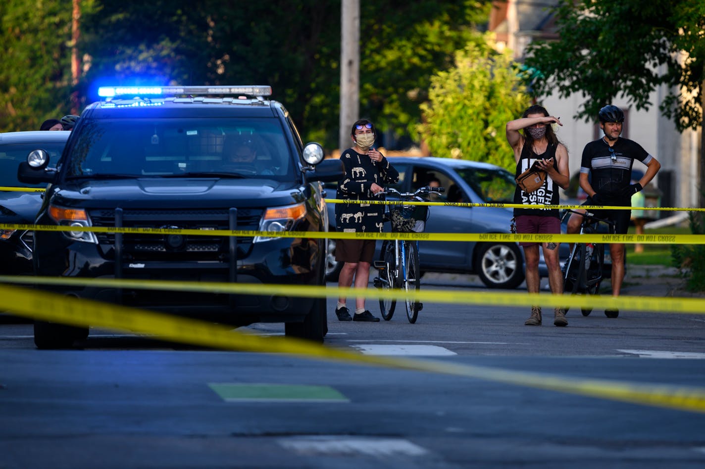 Onlookers watched the homicide investigation Thursday near the George Floyd memorial in south Minneapolis. ]