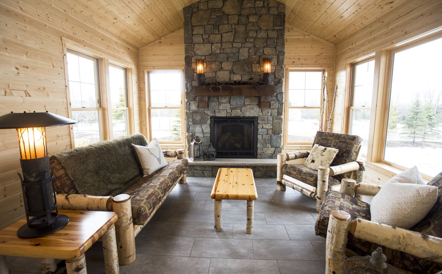 The Teigens moved their rustic birch-log furniture from their old house to the new pine-clad four-season porch, which is warmed by a stone fireplace.