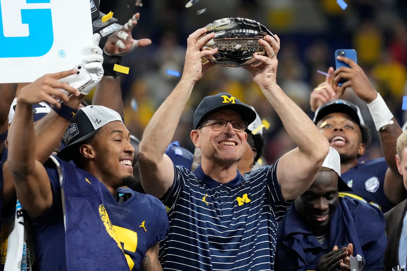 FILE - Michigan head coach Jim Harbaugh holds the trophy as he celebrates with his team after defeating Purdue in the Big Ten championship NCAA college football game, early Sunday, Dec. 4, 2022, in Indianapolis. Michigan is the two-time defending Big Ten champion, and Harbaugh said his 2023 team could be the best he's had since taking over the Wolverines in 2015. (AP Photo/AJ Mast, File)