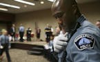 New Minneapolis Police Department Academy graduate Michael Griffin pins his badge onto his uniform moments after receiving it from Police Chief Tim Do