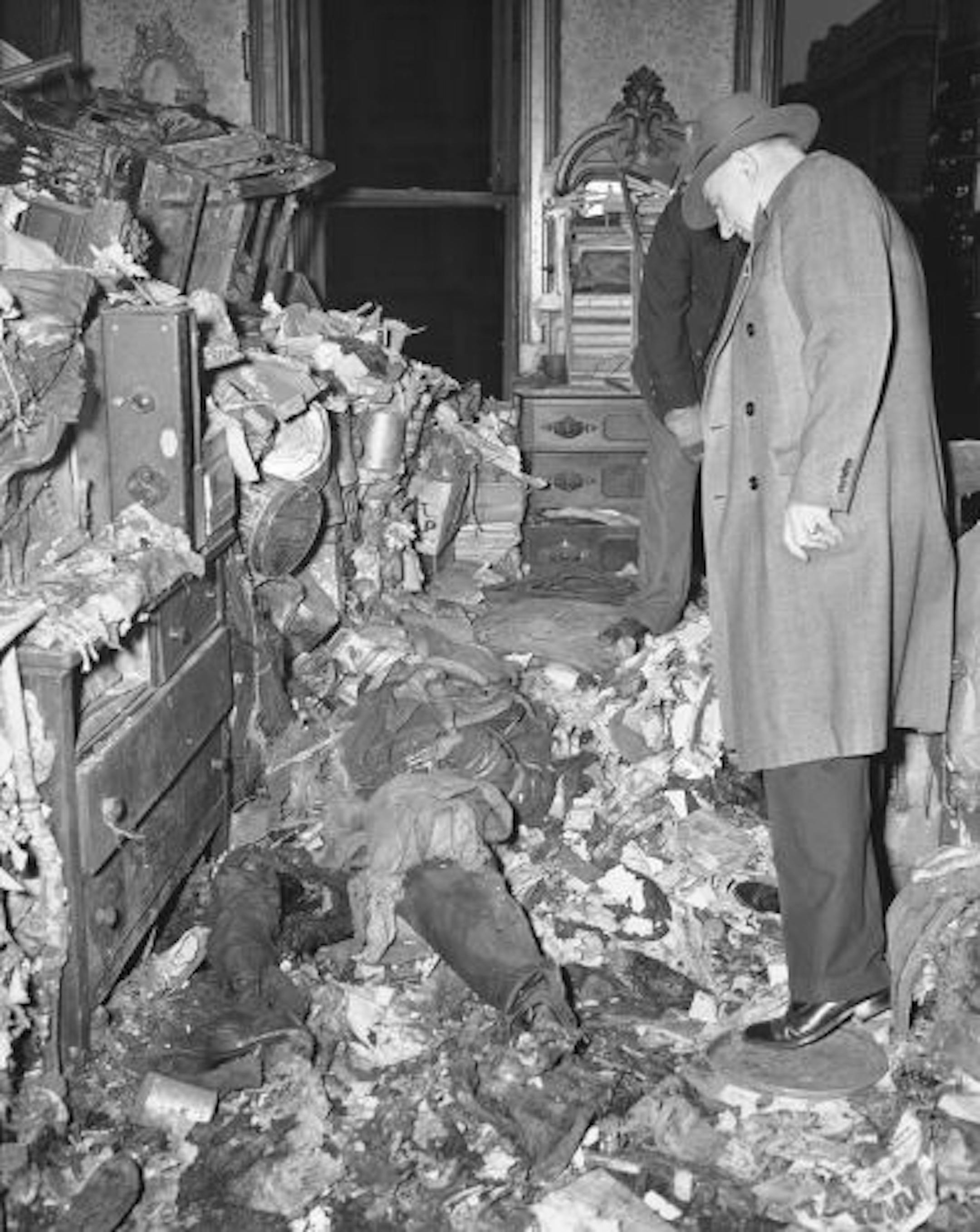 An unidentified detective looks at the body of Langley Collyer, 61-year-old recluse, April 8, 1947, after a layer of four feet of rubbish had been cleared away following the discovery of the missing man, in the same room of the ancient mansion on upper Fifth Avenue in New York in which the body of his blind brother, Homer, was found on March 21.Parts of the body had been gnawed by rats. This fact led police to think that he had died before Homer.