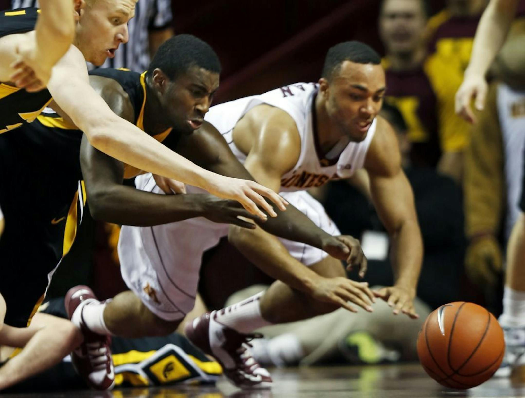 Iowa players Aaron White (30) and Anthony Clemmons (5) scramble for a loose ball with Joe Coleman.