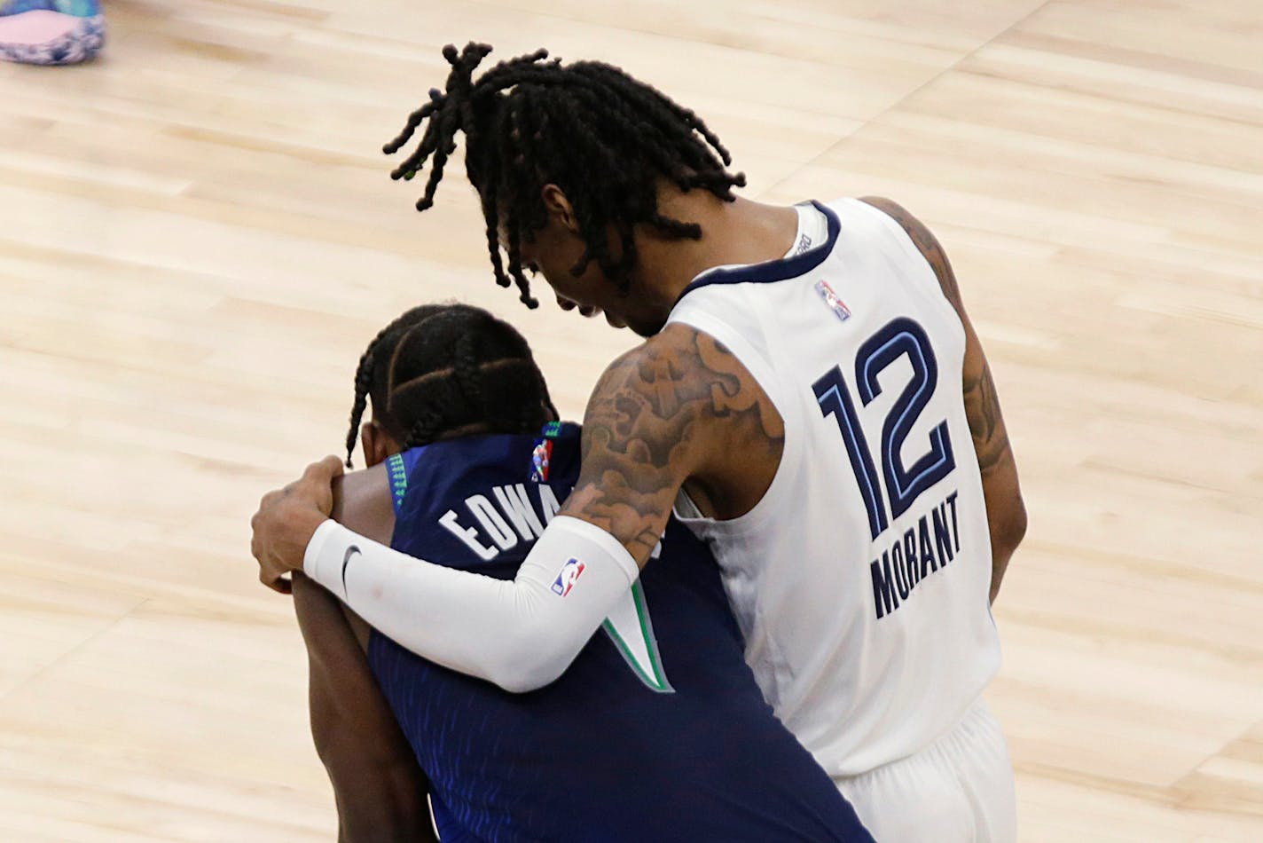 Memphis Grizzlies guard Ja Morant (12) consoles Minnesota Timberwolves forward Anthony Edwards (1) late in the second half of Game 6 in an NBA basketball first-round playoff series Friday, April 29, 2022, in Minneapolis. (AP Photo/Andy Clayton-King)