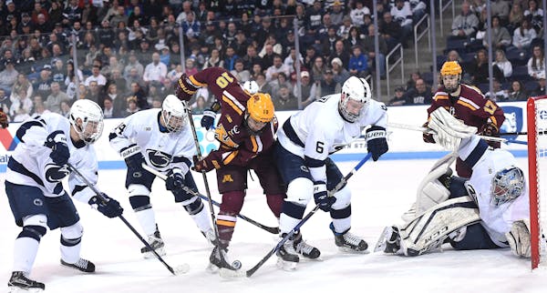 Minnesota�s Brent Gates Jr. (10), fights Penn State defenders James Gobetz (6), Kris Myllari (far left), and Nate Sucese (14) for the puck during Sa