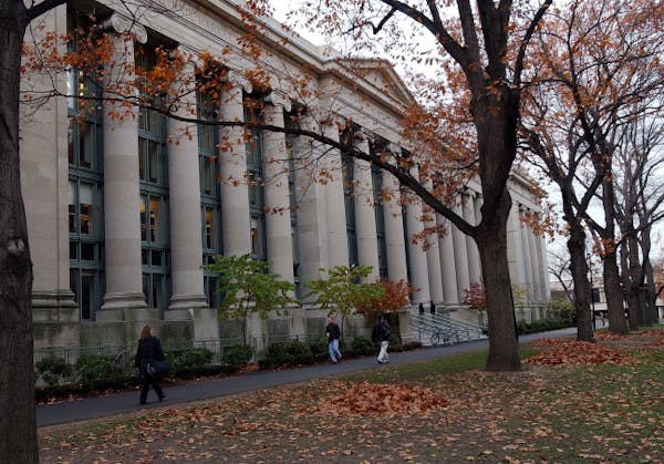 Students walk through the Harvard Law School area on the campus of Harvard University in Cambridge, Mass.