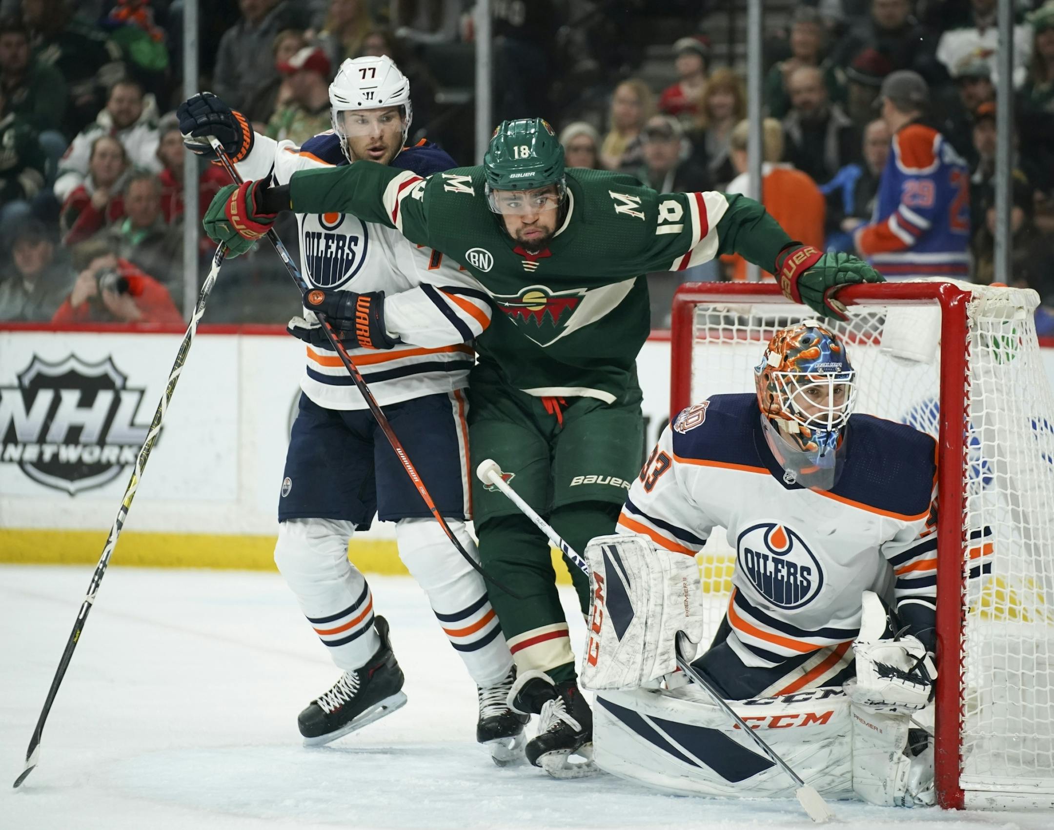 Minnesota Wild left wing Jordan Greenway (18) squeezed between the post and Edmonton Oilers defenseman Oscar Klefbom (77) to get in position in front of Oilers goaltender Cam Talbot in the second period.