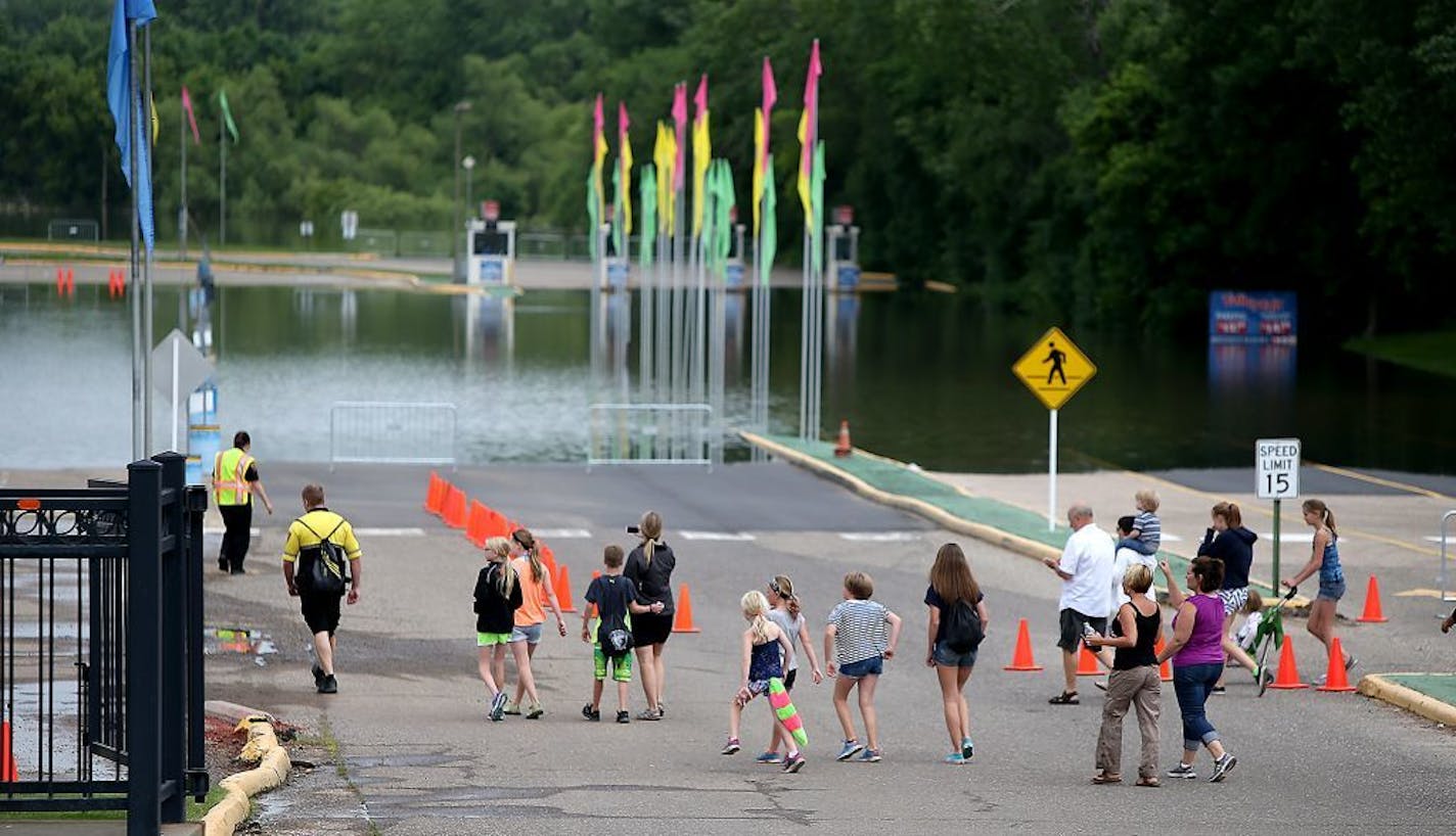 Valleyfair enthusiasts made their way into the amusement park near a flooded parking lot, Wednesday, June 25, 2014 in Shakopee. Parking at the park is currently free.