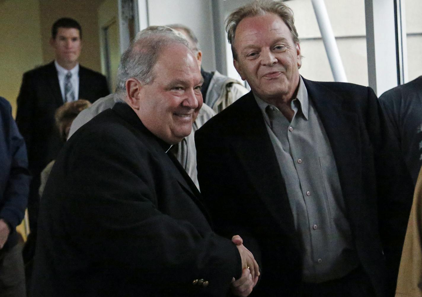 Archbishop Bernard Hebda, left, clergy abuse survivor Jamie Huetmaker shook hands after a U.S. Bankruptcy Court approved a settlement plan that includes $210 million for more than 400 victims of clergy sex abuse.