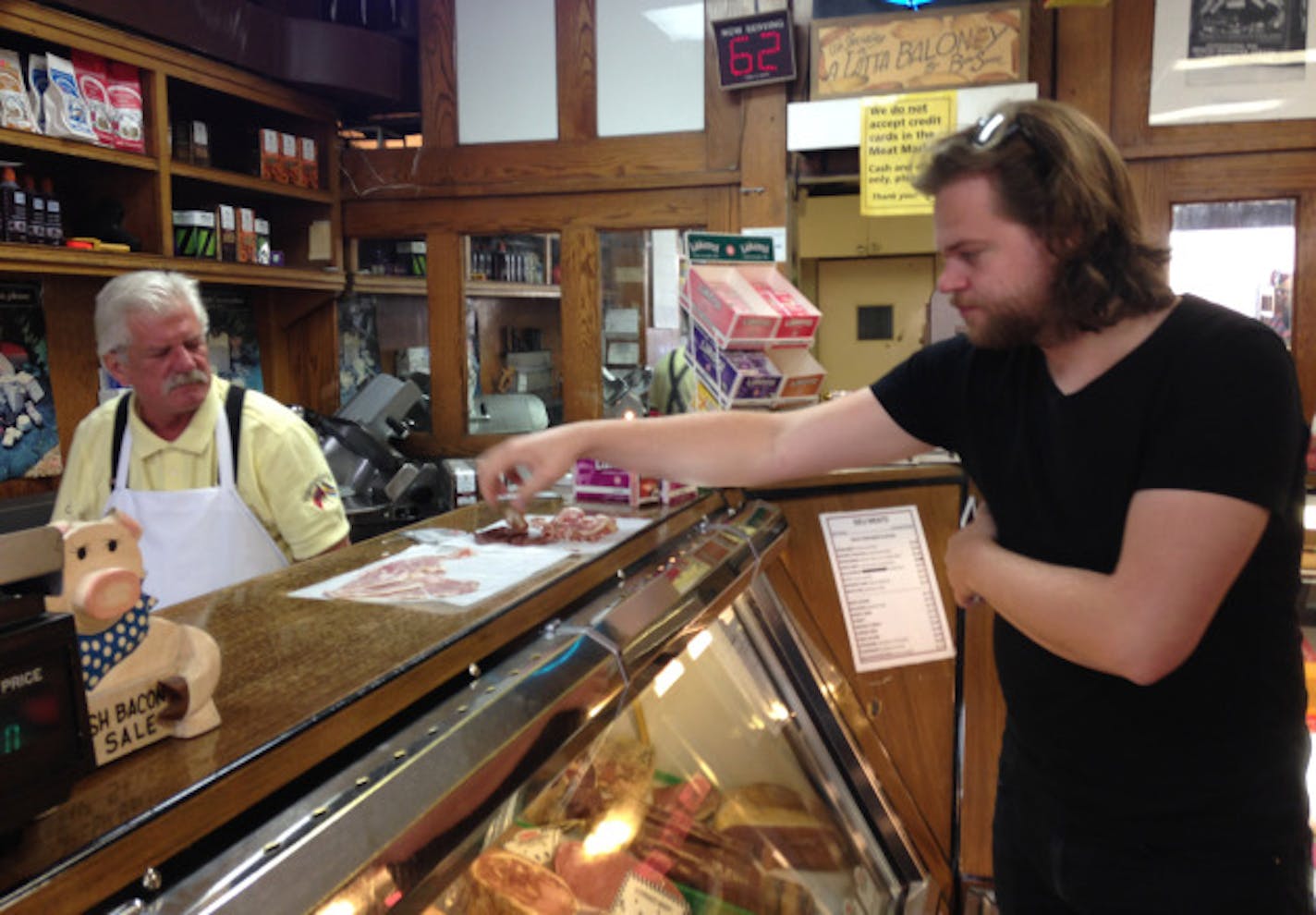 Butcher Gary Coleman offers house-smoked meats to Magnus Nilsson.