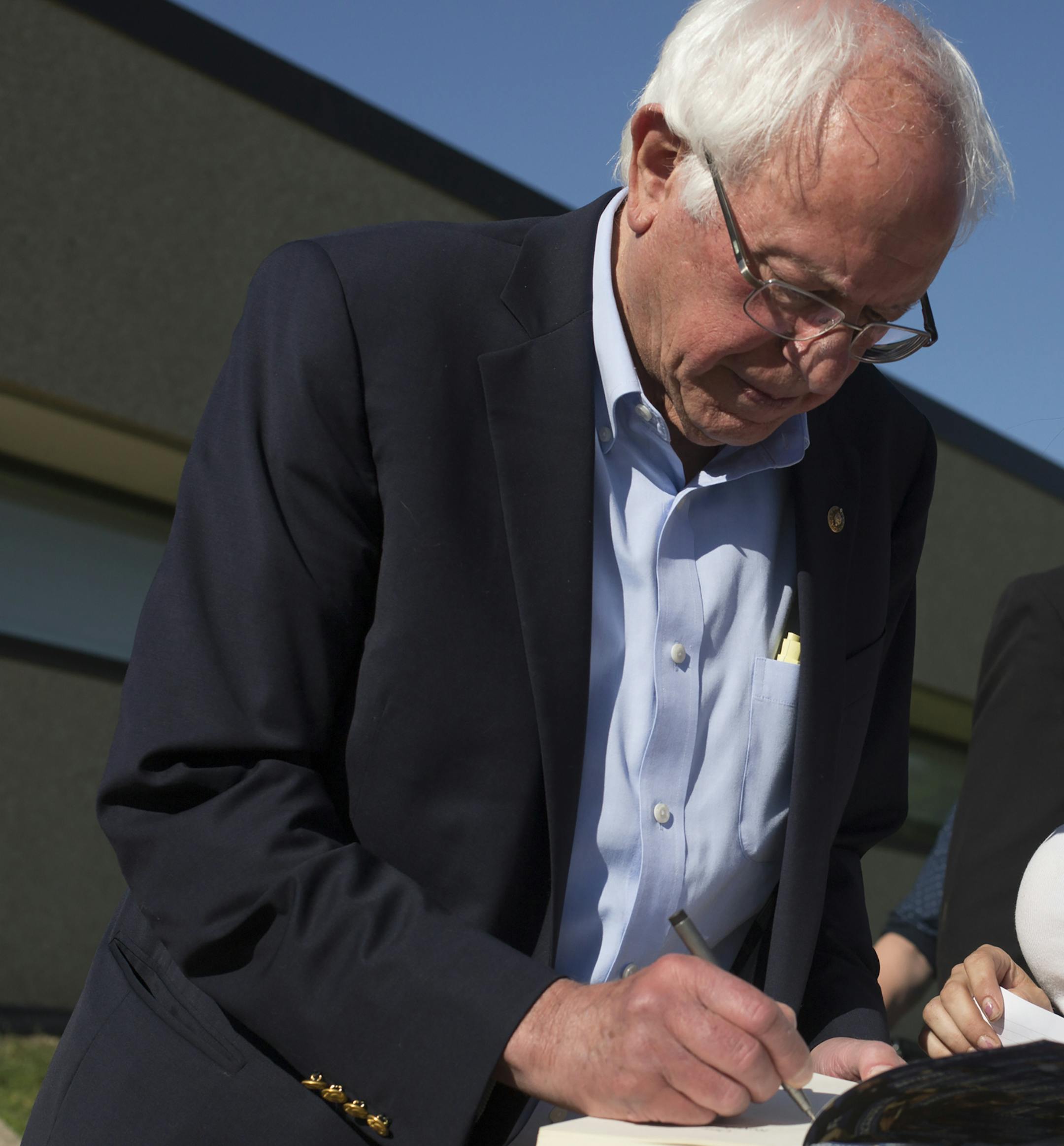 Sen. Bernie Sanders (I-Vt.), a Democratic candi­date for presi­dent, signs a book for Jenna Nation after a town hall forum in Marshalltown, Iowa, June 8, 2019. (Rachel Mummey/The New York Times)