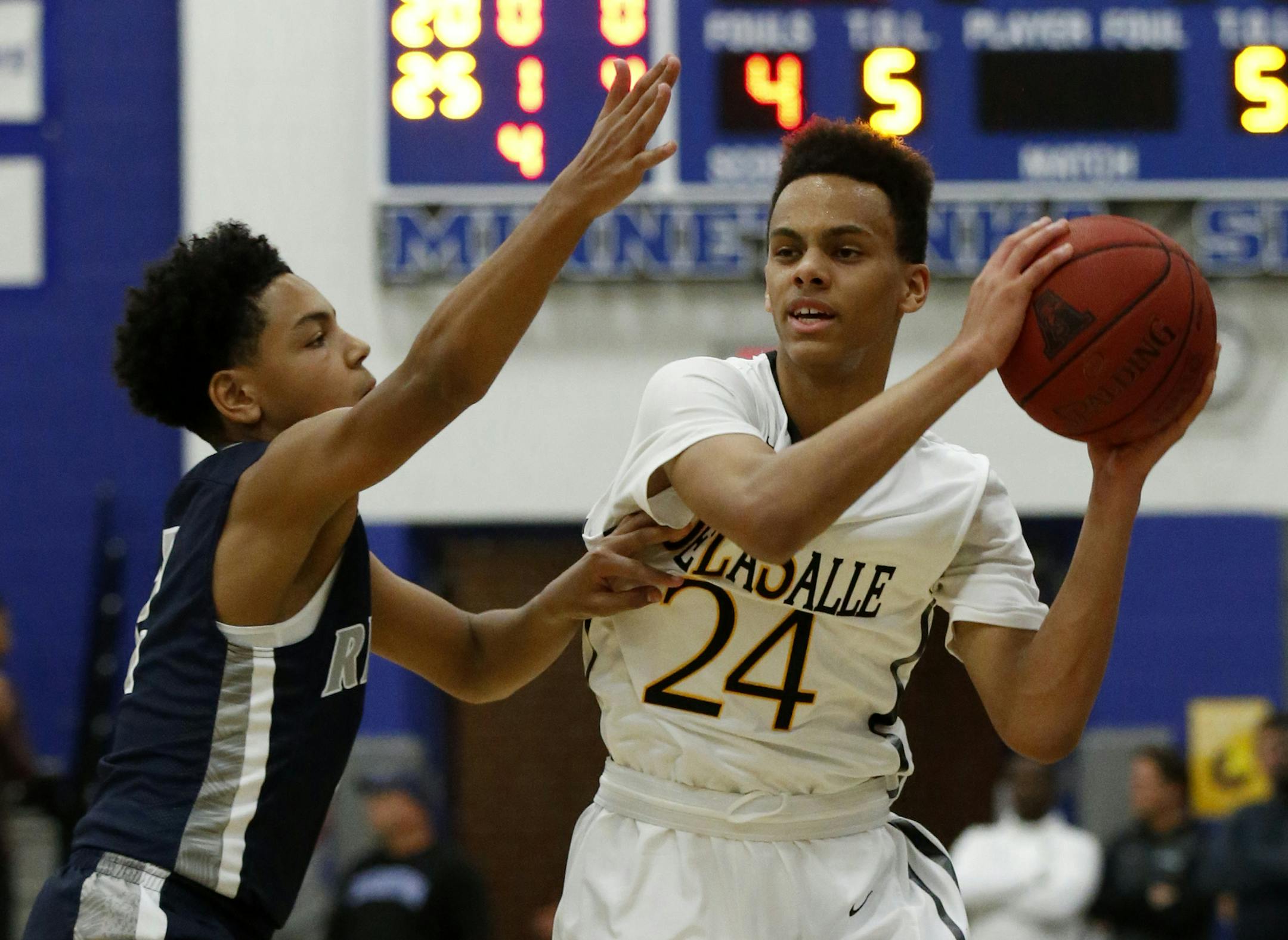 DeLaSalle guard Christian Dickson (24) looks to pass under pressure from Champlin Park guard Josiah Stron during the first half in Minnetonka, Saturday, Dec. 12, 2015. ( Photo/Ann Heisenfelt) ORG XMIT: 596959 PREP121315 25