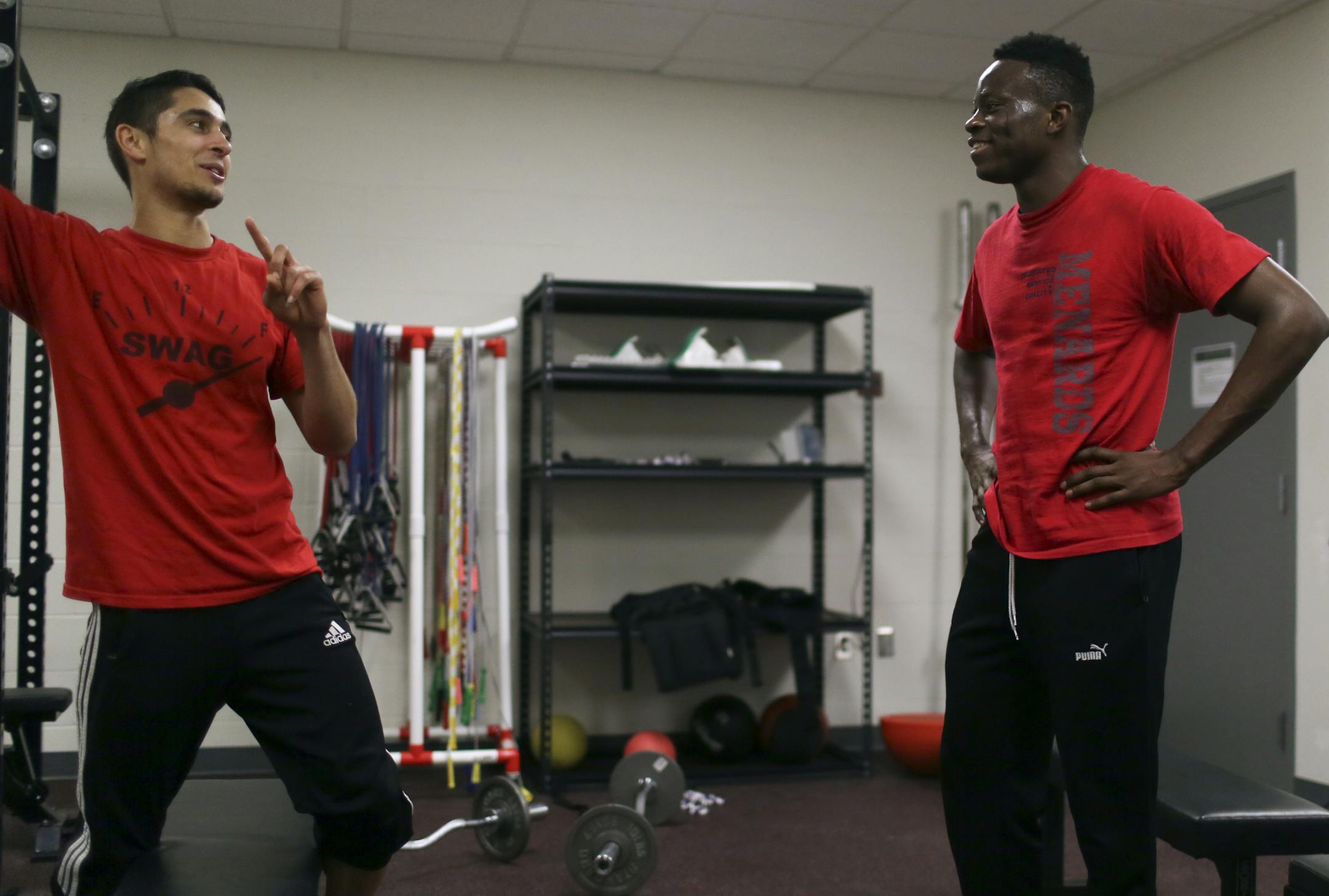 Moise Damey, known as CJ, has been waiting with his mother for a hearing in US Immigration Court. His mother is seeking asylum from Guinea. Their first hearing was in 2012. Their next scheduled hearing is in 2015. In the meantime, Damey, 19, who attends Prairie Seeds Academy in Brooklyn Park, MN, waits in limbo. Damey, right, was seen at track practice talking to fellow sprinter Mournier Peterson- Darbaki Wednesday, March 19, 2014, at Prairie Seeds Academy.](DAVID JOLES/STARTRIBUNE) djoles@start