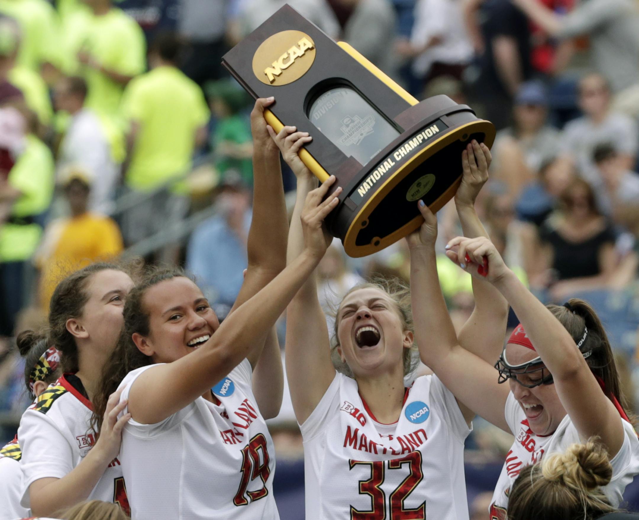 Maryland's Alex McKay (19), Bairre Reilly (32) and Meghan Doherty, far right, celebrate with the trophy after they defeated Boston College to win the NCAA college Division 1 lacrosse championship final, Sunday, May 28, 2017, in Foxborough, Mass. (AP Photo/Elise Amendola)