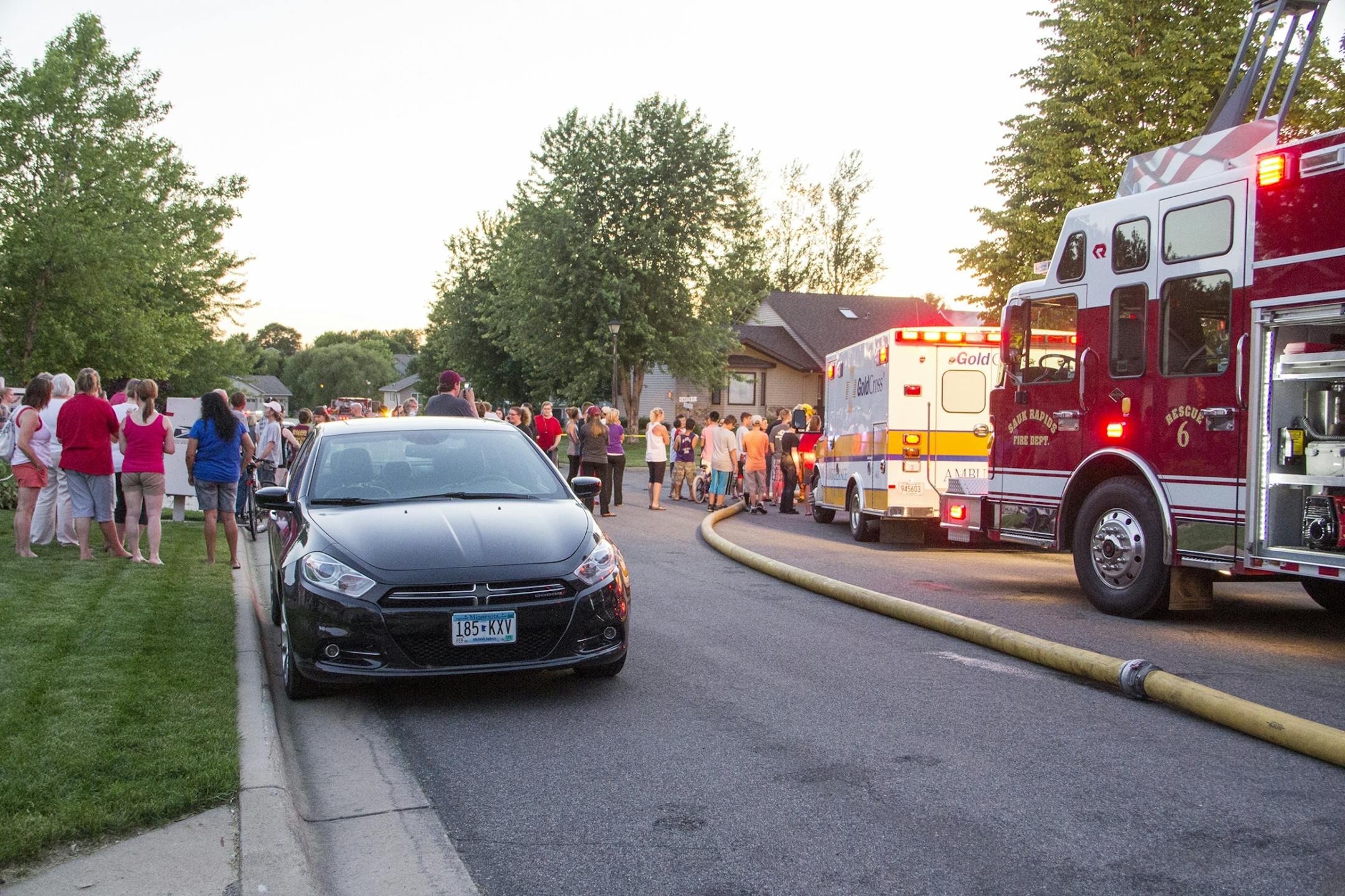 Crowds gather to watch fire fighters extinguish a fire that started Friday at 31 Garden Place, Sauk Rapids after a plane crash.