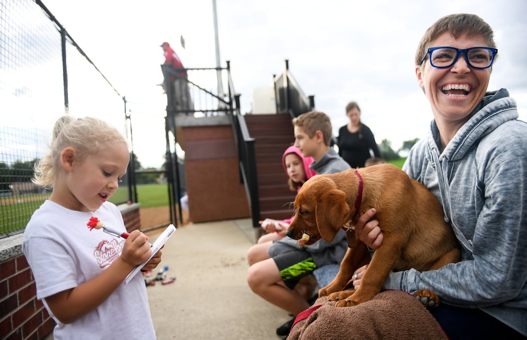 Clara Stalboerger, 5, took a food order from Emily Jonas, of Cold Spring, as she held her 3-year old dog, Arlo, in her lap during Farming Invitational Tournament