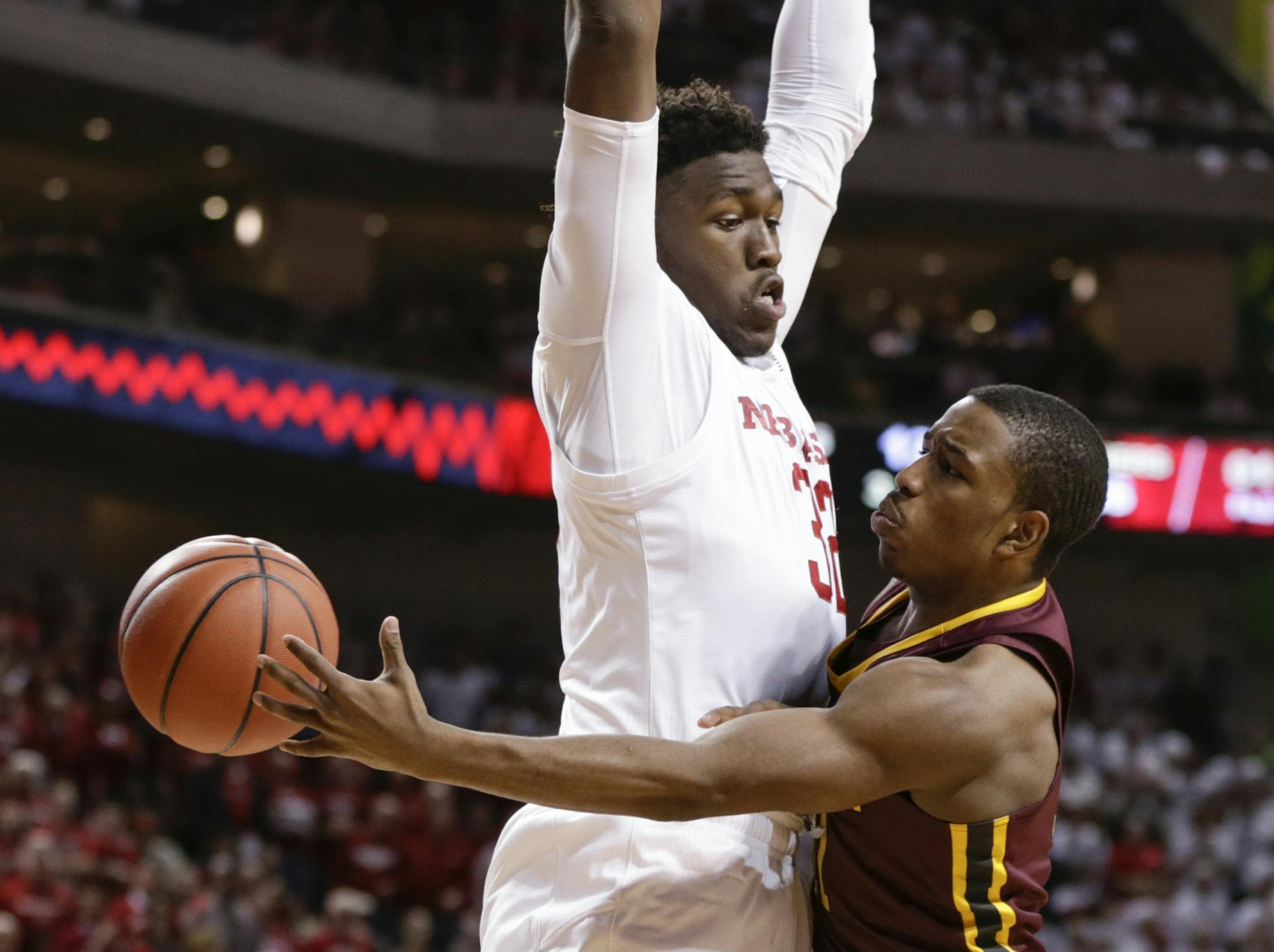 Minnesota's Isaiah Washington (11) passes the ball around Nebraska's Jordy Tshimanga (32) during the second half of an NCAA college basketball game in Lincoln, Neb., Tuesday, Dec. 5, 2017. Nebraska won 78-68.
