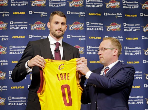 Cleveland Cavaliers' Kevin Love holds up his new jersey with general manager David Griffin at the NBA basketball team's practice facility in Independe